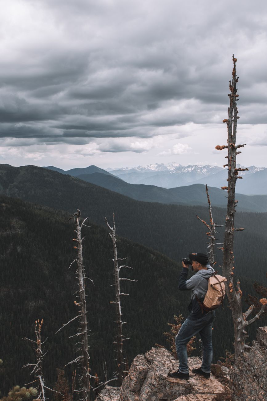 Photographer overlooking misty mountain summit